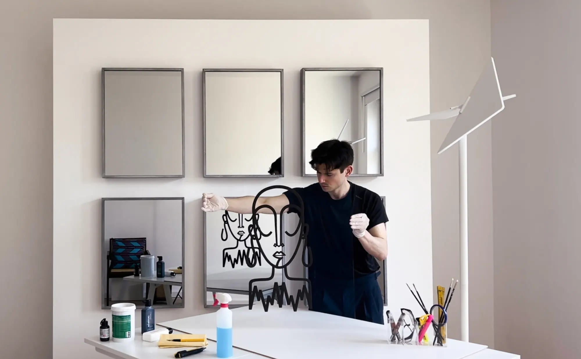 Faby Dichro zeichnet im Atelier eine Linie auf eine Spiegelarbeit