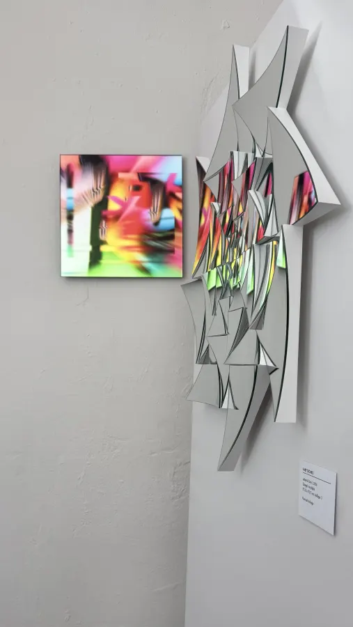 Spiegelskulptur mit einem pinken Quadrat an der Wand